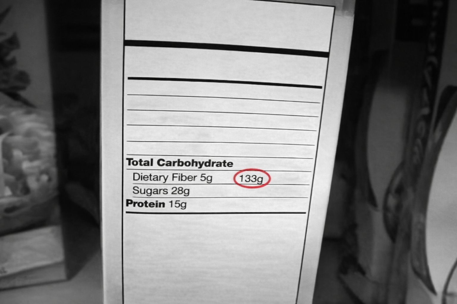 Svartvit näringsdeklaration som visar 133g kolhydrater, 5g fiber, 28g socker, 15g protein.